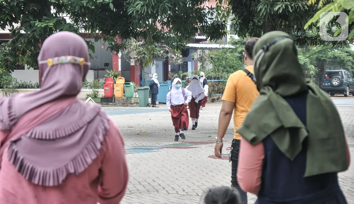Orang tua murid saat menjemput di halaman sekolah usai mengikuti Pembelajaran Tatap Muka (PTM) Terbatas di SDN Malaka Jaya 07 Pagi, Klender, Jakarta, Senin (30/8/2021). Kegiatan(merdeka.com/Iqbal S. Nugroho)