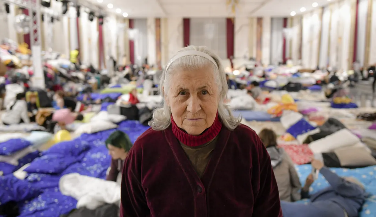 Nellya Nahorna, 85 tahun, yang melarikan diri dari invasi Rusia dari Zaporizhzhia bersama putrinya Olena Yefanova, berpose di dalam ballroom yang diubah menjadi tempat penampungan pengungsi darurat di hotel & spa bintang 4, di Suceava, Rumania, 4 Maret 2022. (AP Photo/Andreea Alexandru)