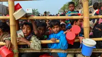 Anak-anak pengungsi muslim Rohingya menunggu bantuan makanan di kamp pengungsi Thankhali di Distrik Ukhia, Bangladesh, (12/1). Mereka melarikan diri bersama orangtuanya saat konflik pecah di Myanmar. (Munir UZ ZAMAN/AFP)