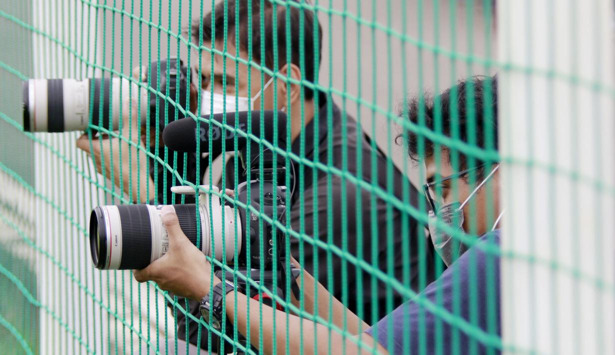 Dua orang wartawan merekam kegiatan latihan Timnas Indonesia di Lapangan D, Senayan, Jakarta. (Bola.com/ M Iqbal Ichsan)