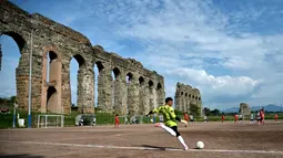 Suasana saat pemain bertanding sepak bola di lapangan Campo Gerini, Roma, Italia, 8 Mei 2016. Lokasi ini berada di bawah saluran air kuno Roma. (FILIPPO MONTEFORTE/AFP)
