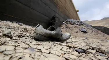 Sebuah sepatu terlihat di dasar Bendungan Ajuan Khota yang mengalami kering, di dekat La Paz, Bolivia, (17/11). Bendungan tersebut, salah satu tempat yang menyimpan cadangan air terbesar. (REUTERS/David Mercado)