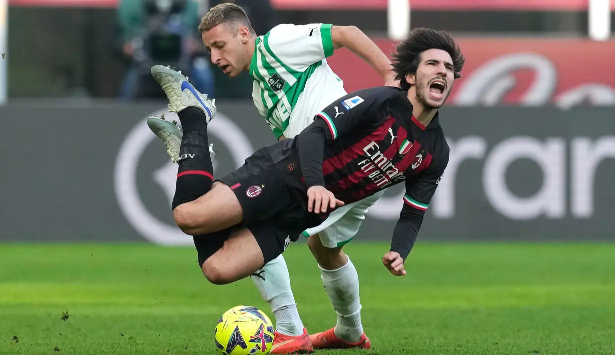Pemain AC Milan Sandro Tonali (kanan) dilanggar oleh pemain Sassuolo Davide Frattesi pada pertandingan sepak bola Liga Italia di Stadion San Siro, Milan, Italia, 29 Januari 2023. AC Milan dipermalukan 2-5 oleh Sassuolo. (AP Photo/Antonio Calanni)
