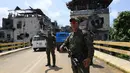 Militer Filipina berjaga di Kota Marawi, Mindanao, Filipina, Minggu (1/4). Pemulangan warga Marawi akan dilakukan secara bertahap hingga pembangunan kembali kota itu dilakukan. (TED ALJIBE/AFP)