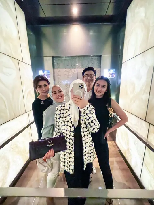 Dipadukan dengan blouse dan celana hitam, serta clutch ungu dari Hermes. [instagram/princessyahrini]