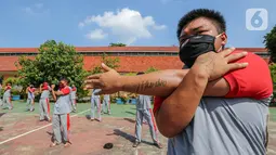 Anak binaan melakukan peregangan otot atau stretching di lapangan Lembaga Pembinaan Khusus Anak (LPKA) Klas 1 Tangerang, Banten, Sabtu (30/5/2020). Stretching dengan physical distancing selama pandemi Covid-19 meningkatkan sistem imunitas tubuh terjaga dengan baik (Liputan6.com/Fery Pradolo)