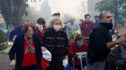Sejumlah warga menyelamatkan diri saat asap kebakaran hutan mulai menyelimuti kawasan tempat tinggal mereka di Haifa, Israel, Kamis (24/11). Diduga 50 persen kebakaran hutan ini adalah faktor kesengajaan. (REUTERS / Baz Ratner)