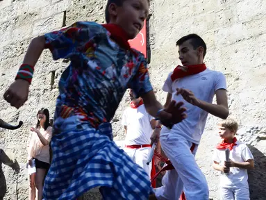 Anak-anak berlarian saat mengikuti Encierro Txiki selama Festival San Fermin di Pamplona, Spanyol (13/7). Encierro Txiki  atau Small Bull Run ini adalah bagian dari Festival San Fermin yang khusus untuk anak-anak. (AFP Photo/Ander Gillenea)