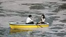 Orang-orang yang memakai masker menikmati mekarnya bunga sakura dari perahu dayung di Tokyo, Senin (29/3/2021). Menyaksikan sakura dari atas perahu dayung sambil menyusuri aliran sungai memberikan pengalaman berbeda. (AP Photo/Koji Sasahara)