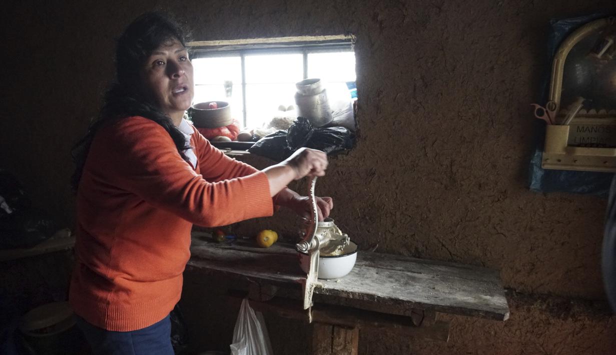 Calon ibu negara Peru, Lilia Paredes (48) menggiling potongan keju saat menyiapkan sarapan di dapur rumahnya yang terbuat dari batako di Chugur, 22 Juli 2021. Suaminya, Pedro Castillo yang merupakan mantan guru dan pemimpin serikat pekerja memenangkan pemilihan presiden Peru. (AP/Franklin Briceno)