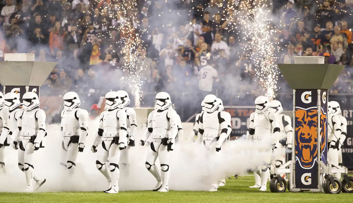 Pasukan Stormtroopers berjalan di lapangan saat istirahat pertandingan NFL antara Chicago Bears dan Minnesota Vikings di Chicago (9/10). Kedatangan karakter star wars ini untuk mempromosikan Star Wars: The Last Jedi. (Kena Krutsinger/Getty Images/AFP)