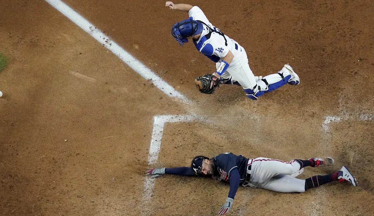 Pemain Atlanta Braves Nick Markakis mencetak gol melewati penangkap Los Angeles Dodgers Will Smith dengan dua gol oleh Cristian Pache selama inning kelima dalam Game 2 dari Seri Kejuaraan Liga Nasional bisbol di Arlington, Texas, Selasa (13/10/2020). (AP Photo/David J. Phillip)