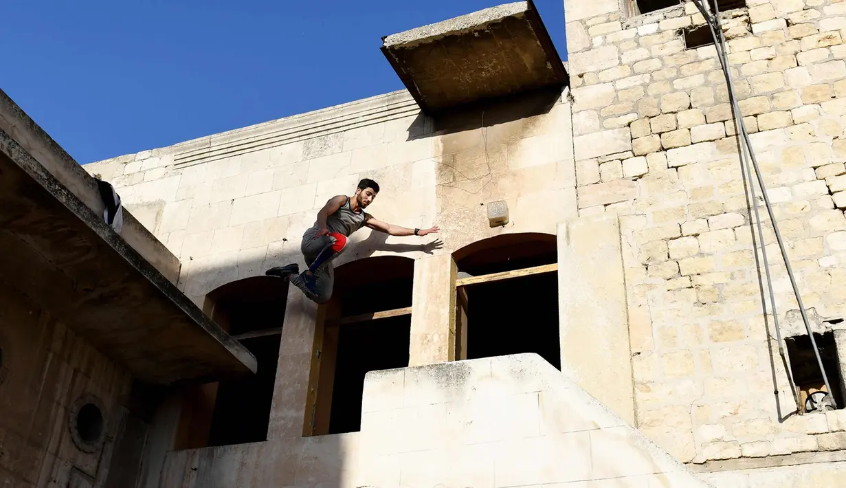 Seorang pemuda melompat berlatih parkour di Aleppo, Suriah, (7/4). Setelah pemerintah Suriah mengambil alih kendali penuh Aleppo dari pasukan pemberontak Desember 2016, beberapa pemuda kini menyalurkan hobinya, yaitu parkour.  (AFP Photo/George Ourfalian)