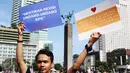Seorang pria membawa poster saat aksi di CFD, Jakarta, Minggu (19/3). Aktivis Gerakan Sapu Koruptor meminta kepada pemerintah untuk menghentikan Revisi Undang-undang KPK. (Liputan6.com/Angga Yuniar) 