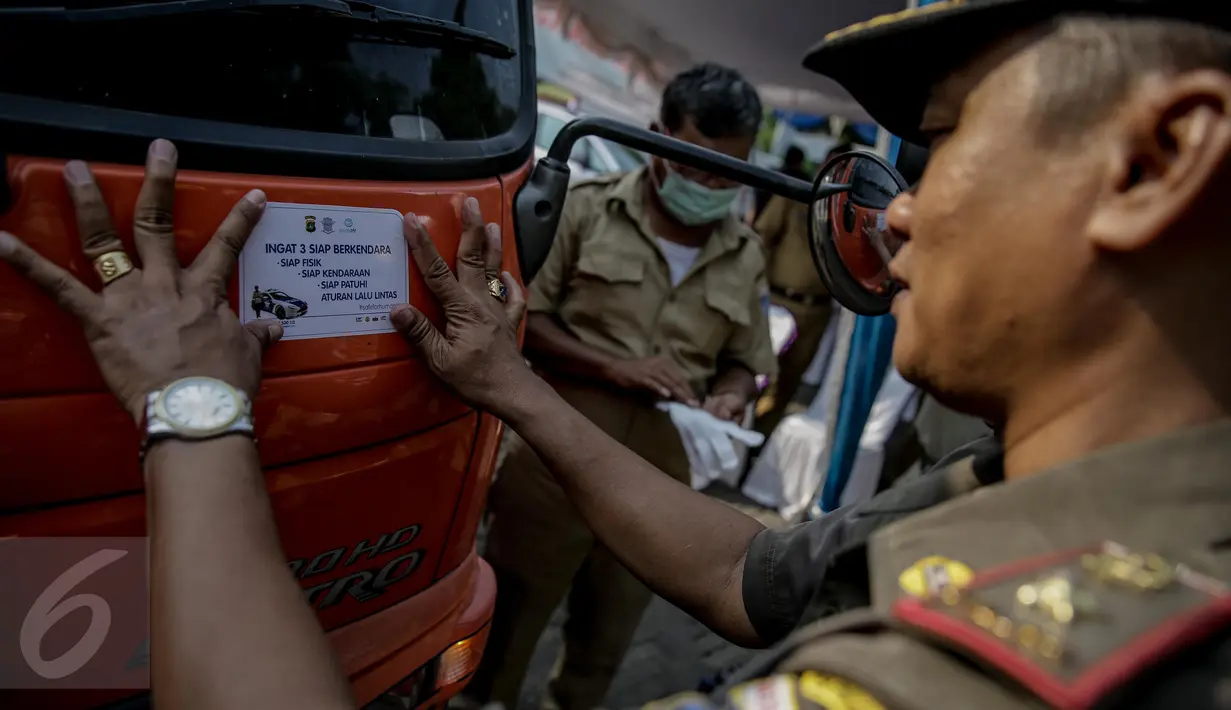 Petugas menempel stiker di kendaraan setelah melakukan uji emisi di kawasan Tugu Proklamasi, Jakarta, Selasa (16/5). Sudin Lingkungan Hidup Jakpus menggelar uji emisi guna meningkatkan kualitas udara bersih bebas polusi. (Liputan6.com/Faizal Fanani)