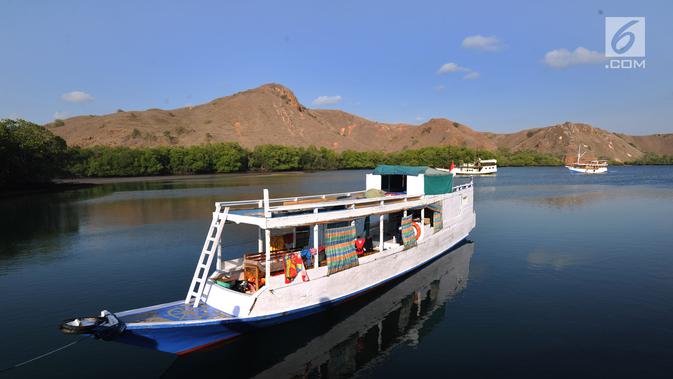 Perahu wisatawan ditambatkan pada sebuah teluk di Pulau Rinca, Taman Nasional Komodo, NTT, Minggu (14/10). Pulau Rinca merupakan bagian dari Situs Warisan Dunia UNESCO. (Merdeka.com/Arie basuki)