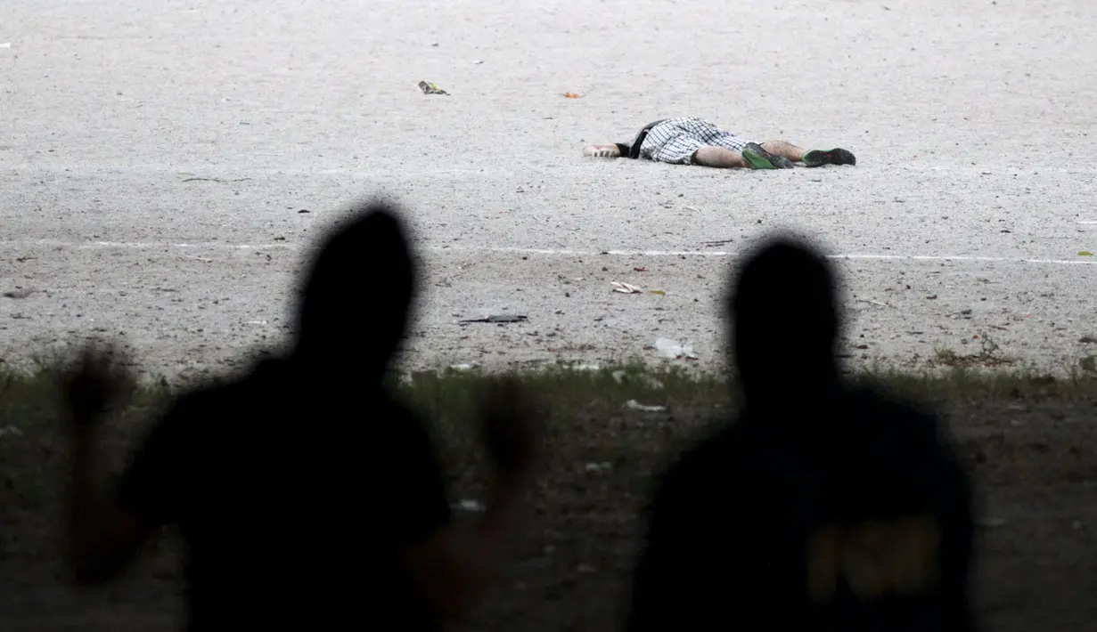 Polisi memeriksa salah satu korban pembunuhan d i sebuah lapangan sepak bola, Cuscatancingo, El Salvador, Minggu (2/8/2015).  Peristiwa ini menewaskan lima orang dan satu luka-luka setelah ditembak  anggota geng Mara Salvatrucha. (REUTERS/Jose Cabezas)