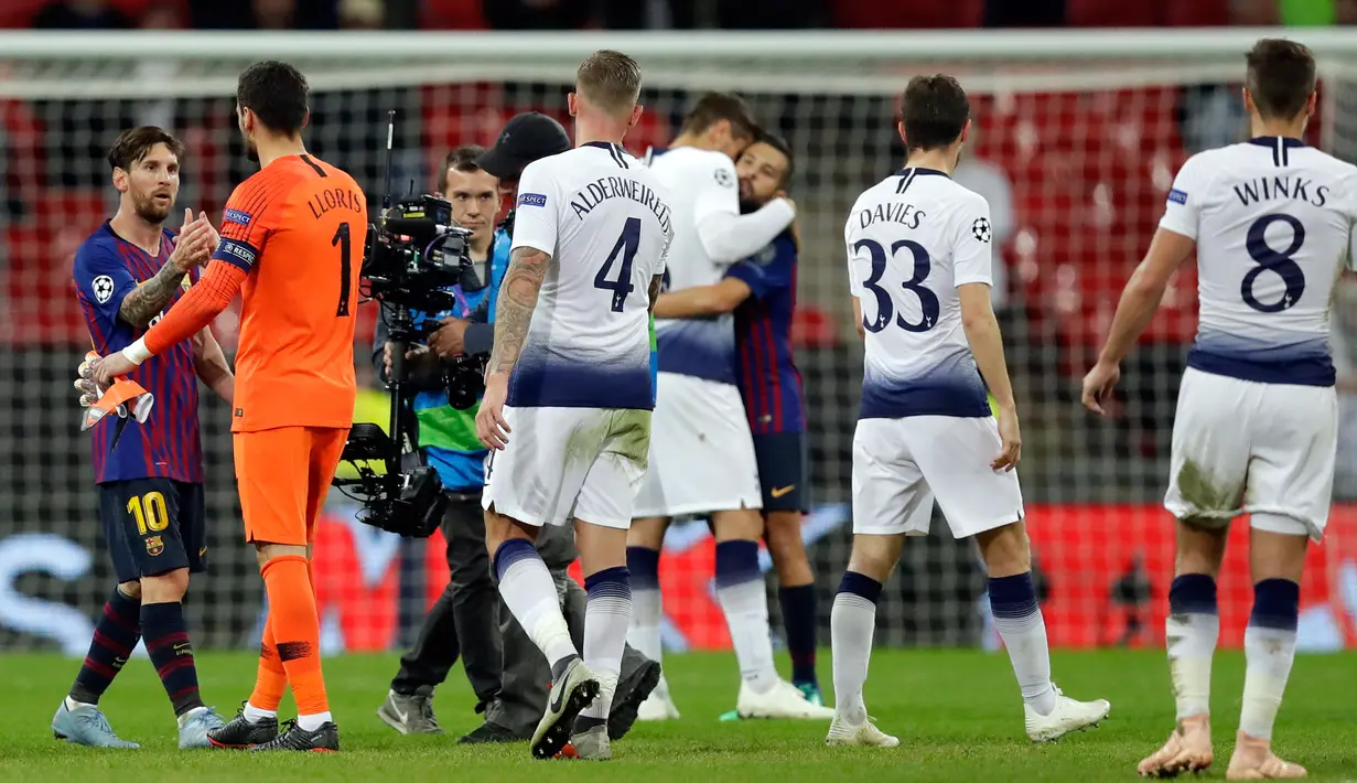 Pemain Barcelona, Lionel Messi (kiri) bersalaman dengan kiper Tottenham Hotspur Hugo Lloris usai pertandingan Liga Champions di Stadion Wembley, London, Rabu (3/10). Messi menyumbang 2 gol saat Barcelona membantai Tottenham. (AP Photo/Kirsty Wigglesworth)