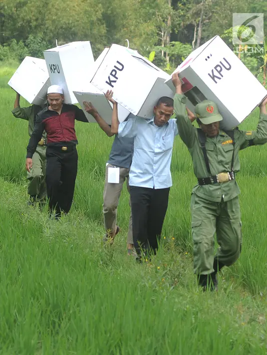 Petugas KPPS membawa logistik Pemilu 2019 melintasi sawah menuju TPS di Desa Cidokom, Bogor, Selasa (16/4). Dalam hitungan jam, lebih dari 200 juta penduduk Indonesia akan segera menyalurkan hak pilihnya dengan mendatangi TPS yang tersebar di 34 Provinsi di Tanah Air. (Merdeka.com/Arie Basuki)