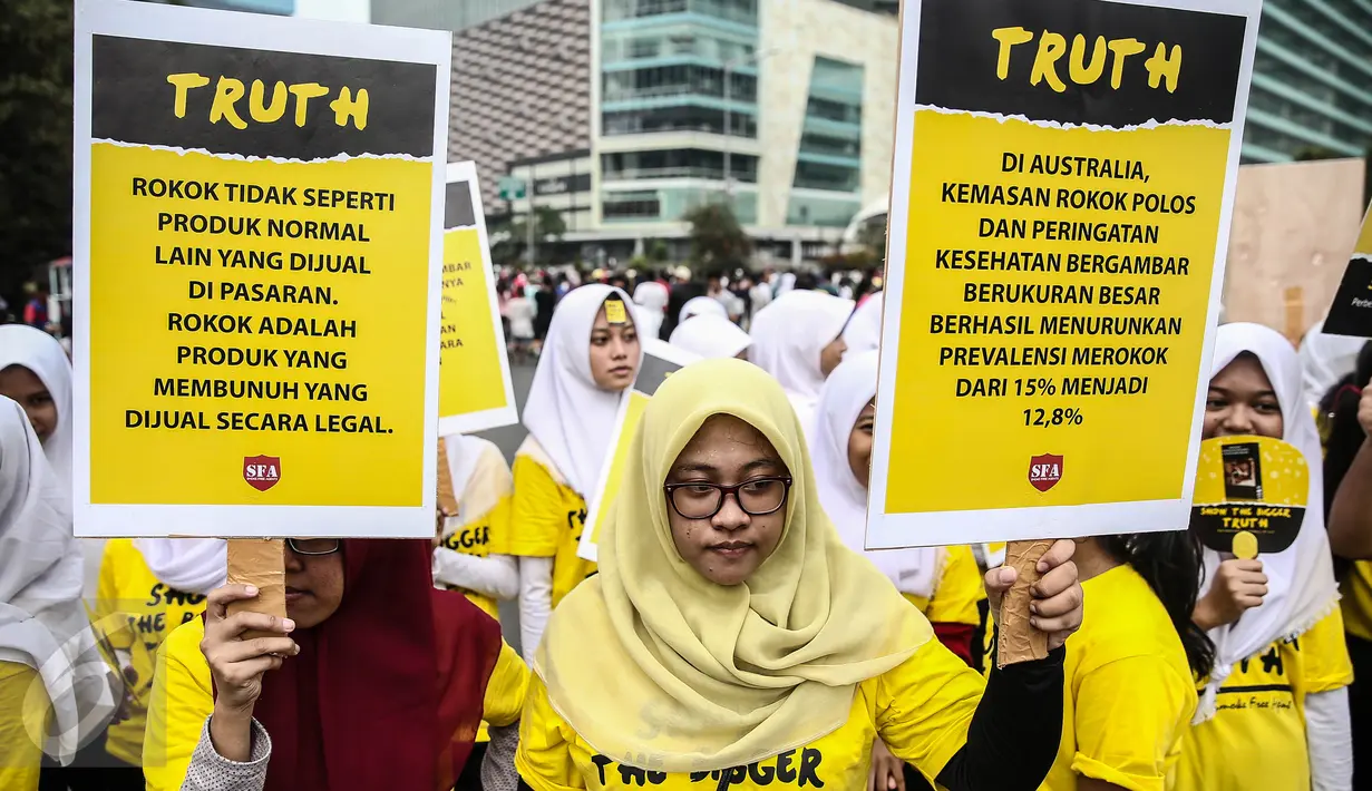 Remaja yang tergabung dalam Smoke Free Agent menggelar aksi damai guna mensosialisasikan bahaya rokok di Bundaran HI, Jakarta, Minggu (5/6). Mereka memberikan peringatan darurat pada pemerintah dalam masalah bahaya rokok. (Liputan6.com/Faizal Fanani)