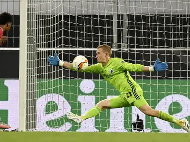 Kiper Copenhagen, Karl-Johan Johnsson, menghalau bola tendangan penyerang Manchester United, Marcus Rashford, pada laga Liga Europa di Stadion Rhein Energie, Senin (10/8/2020). MU menang tipis 1-0 atas Copenhagen. (Sascha Steinbach/Pool via AP)