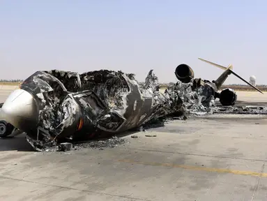 Sisa reruntuhan sebuah pesawat terlihat di Bandara Internasional Tripoli, Libya, (21/7/2014). (REUTERS/Hani Amara)