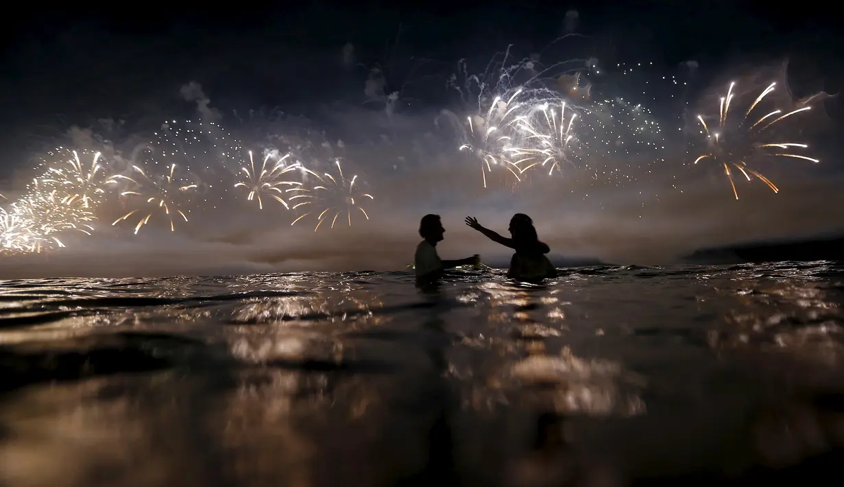 Sejumlah orang saat menyaksikan kembang api di pantai Copacabana saat perayaan Tahun Baru 2016 di Rio de Janeiro, Brasil, (1/1/2016). (REUTERS/Ricardo Moraes)