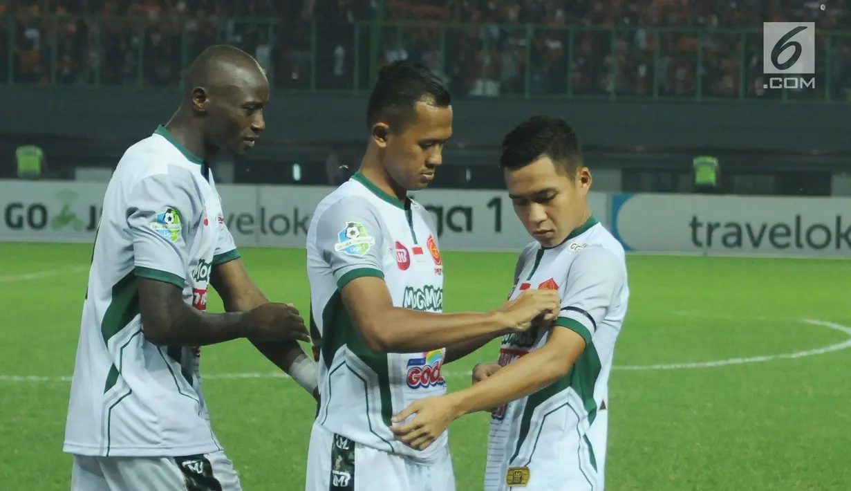 Pemain PS TNI mengenakan pita hitam di lengan jelang laga melawan Persija pada lanjutan Liga 1 Indonesia di Stadion Patriot Candrabhaga, Bekasi, Sabtu (30/9). Pita hitam untuk mengenang para pahlawan revolusi yang gugur. (Liputan6.com/Helmi Fithriansyah)