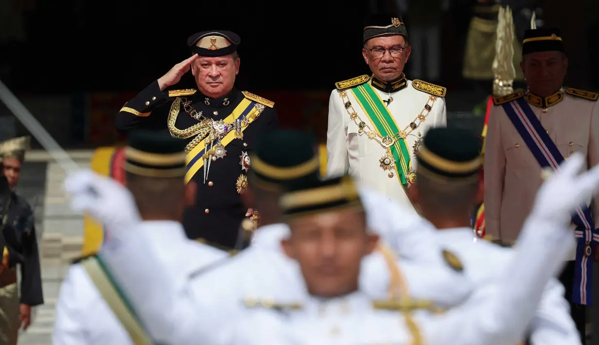 Raja Malaysia ke-17, Sultan Ibrahim Sultan Iskandar dari Johor memberi hormat kepada penjaga kehormatan, di samping Perdana Menteri Malaysia Anwar Ibrahim di Istana Nasional di Kuala Lumpur pada tanggal 31 Januari 2024. (HASNOOR HUSSAIN/POOL/AFP)