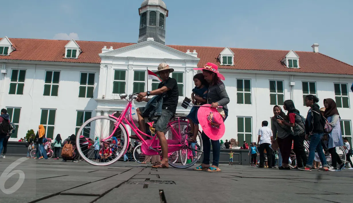 Warga berwisata menaiki sepeda kuno di kawasan Kota Tua, Jakarta, Senin (5/1). Meskipun libur panjang akan berakhir, warga tetap memadati kawasan wisata Kota Tua. (Liputan6.com/Gempur M Surya)