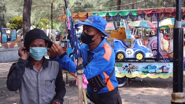 Polres Pemalang bagi masker gratis ke wisatawan dan petugas di objek wisata untuk mengantisipasi Covid-19 pada libur nataru. (Foto: Liputan6.com/Polres Pemalang)