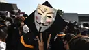 Mahasiswa mengenakan topeng Guy Fawkes selama aksi protes pada upacara kelulusan mereka di Chinese University of Hong Kong, Hong Kong, Kamis (7/11/2019). Sekitar seribu mahasiswa mengabaikan larangan mengenakan topeng yang dikeluarkan pemerintah pada Oktober 2019. (Philip FONG / AFP)