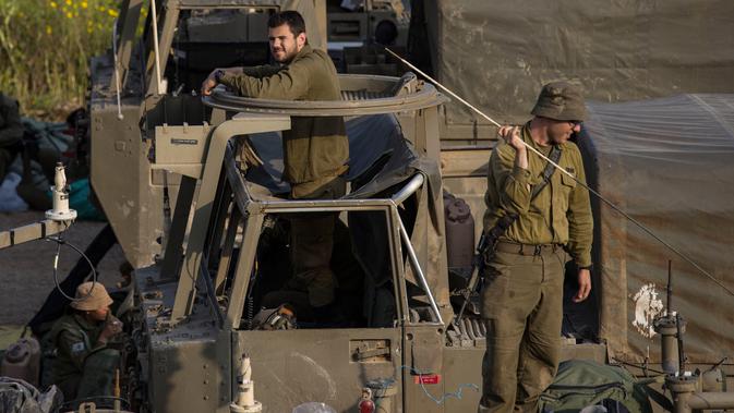 Tentara Israel berdiri di atas artileri di dekat perbatasan dengan Gaza, Rabu (27/3). Pertempuran sengit sempat meletus di wilayah tersebut sebelum akhirnya Hamas menyepakati gencatan senjata yang diinisiasi Mesir, tetapi Israel belum bersikap. (AP Photo/Tsafrir Abayov)