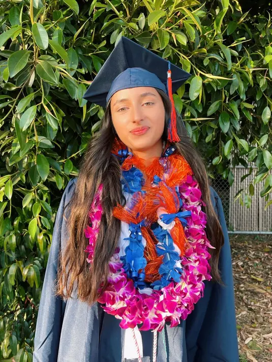 Dalam momen wisuda kelulusan tersebut, Camilla mengenakan toga nuansa navy dan makeup minimalis.