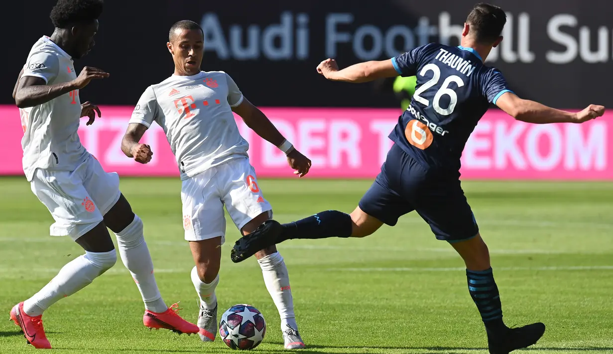 Gelandang Bayern Munchen, Thiago Alcantara dan Alphonso Davies berebut bola dengan penyerang Marseille, Florian Thauvin, pada laga persahabatan di Allianz Arena, Sabtu (1/8/2020) dini hari WIB. Bayern Munchen menang 1-0 atas Marseille. (AFP/Christof Stache/various sources)