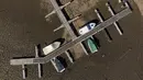 Dalam gambar udara dengan drone, kapal pesiar yang diikat ke dermaga beristirahat di tanah kering dari air yang habis di Sungai Zezere karena kekeringan, dekat Figueiro dos Vinhos di Portugal, 17 Februari 2022. Portugal telah mengalami minim curah hujan sejak Oktober lalu. (AP/Sergio Azenha)