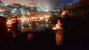 Seorang wanita membawa lampu minyak selama festival Bala Chaturdashi di Kuil Pashupatinath di Kathmandu (6/12). Festival Bala Chaturdashi ini dirayakan untuk mengenang anggota keluarga yang telah tiada. (AFP Photo/Prakash Mathema)