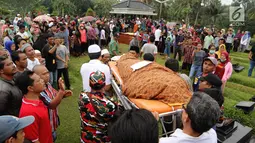 Warga menggotong jenazah korban kecelakaan Tanjakan Emen untuk dimakamkan di Tempat Pemakaman Umum (TPU) Legoso, Tangerang Selatan, Banten, Minggu (11/2). Ratusan keluarga dan kerabat turut hadir di pemakaman. (Liputan6.com/JohanTallo)