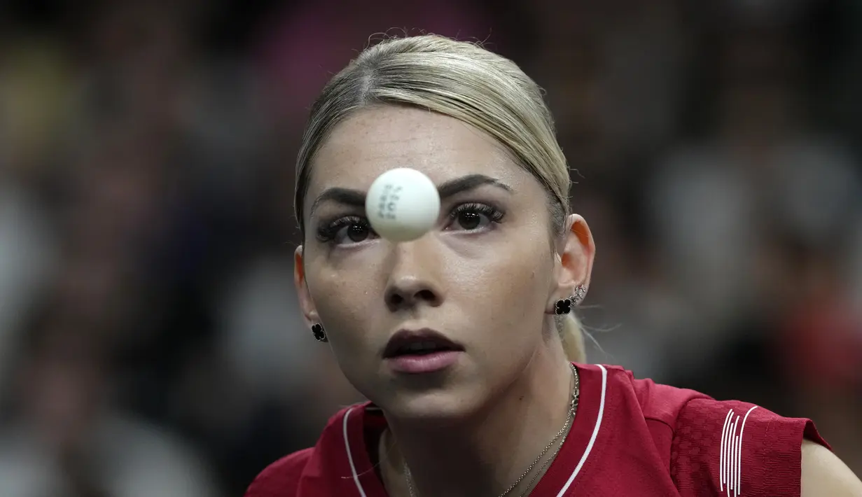 Petenis meja Rumania Bernadette Szoc bermain melawan Sofia Polcanova dari Austria pada pertandingan tenis meja babak 16 besar tunggal putri Olimpiade Paris 2024 di South Paris Arena, Rabu (31/7/2024). (AP Photo/Petros Giannakouris)