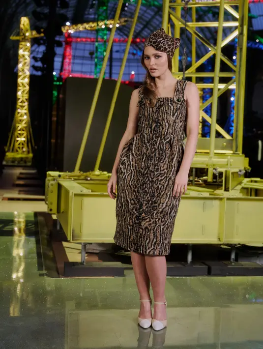 Lily-Rose Depp kenakan midi dress animal print dengan strap lebar. Tampilannya revolusioner dengan headpiece berbentuk kepala leopard [Chanel]