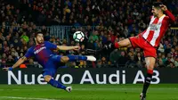 Penyerang Barcelona, Luis Suarez berebut bola dengan pemain Girona, Juanpe Ramirez saat bertanding pada La Liga Spanyol di stadion Camp Nou (25/2). Barcelona menang telak 6-1 atas Girona. (AP Photo/Manu Fernandez)