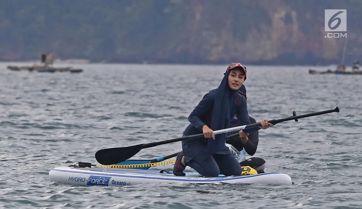 Istri bupati Trenggalek Novita Hardini olah raga Stand Up Paddle di Pantai Mutiara, Trenggalek, Jawa Timur, Sabtu (7/9/2019). Novita dikenal dengan sosok perempuan muda yang cerdas dan cantik. Tak hanya itu, ia juga kerap mendampingi sang suami di berbagai kegiatan. (Liputan6.com/Herman Zakharia)