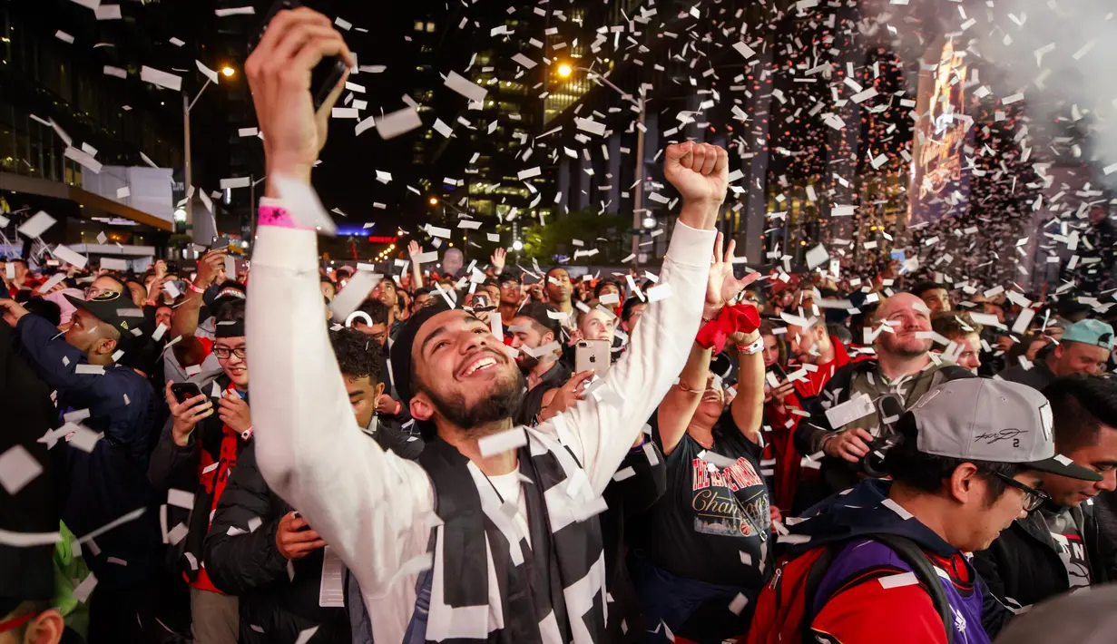 Ekspresi bahagia pendukung Toronto Raptors merayakan kemenangan timnya meraih gelar juara NBA 2019 di pusat kota Toronto, Ontario Kanada. (AFP/Getty Images/Cole Burston)