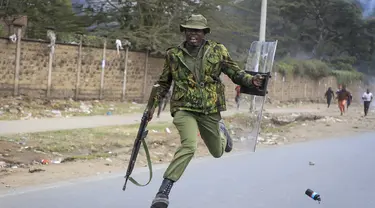 Seorang polisi melompat ketika dia berusaha menghindari granat gas air mata yang dilemparkan kembali ke arah polisi oleh pengunjuk rasa di lingkungan Mathare di Nairobi, Kenya Rabu, 12 Juli 2023. (AP Photo)