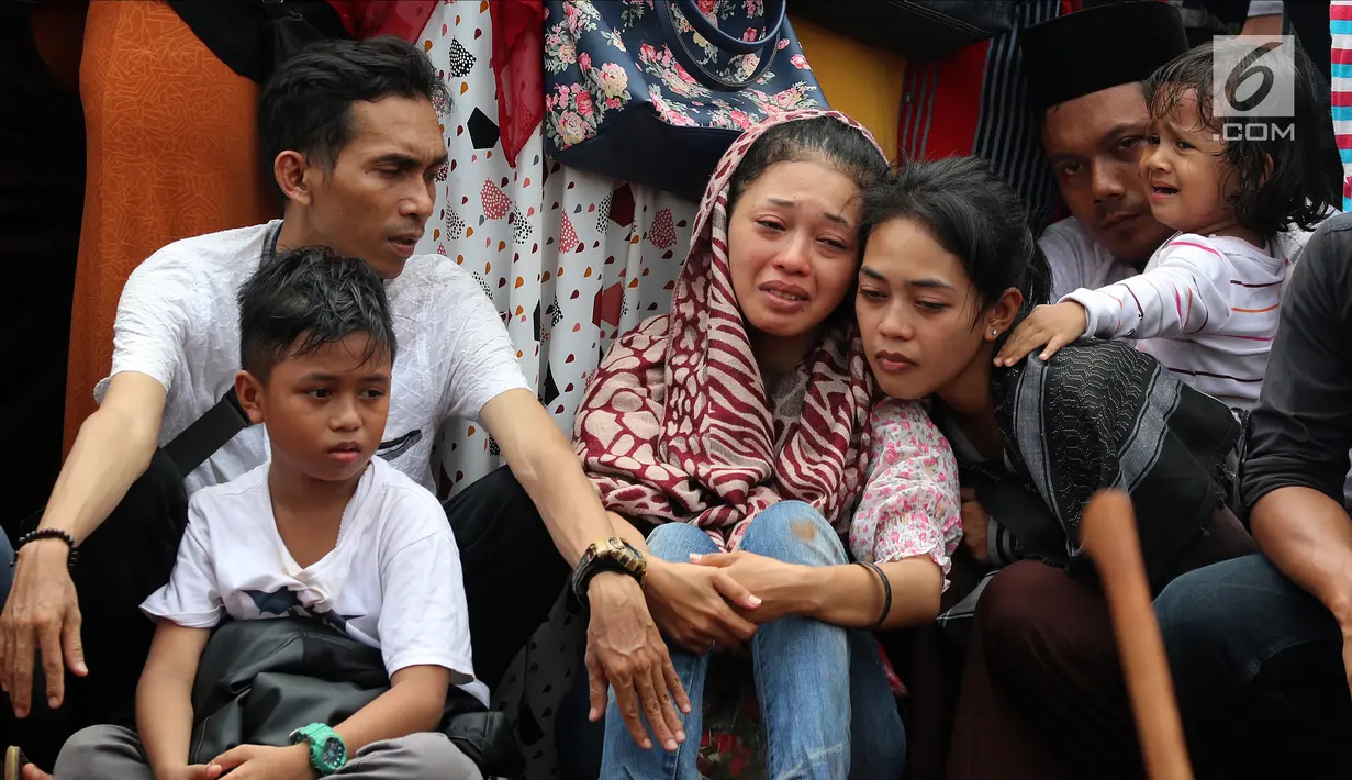 Kesedihan kerabat serta keluarga saat prosesi penguburan massal korban kecelakaan bus di Tanjakan Emen Subang di TPU Legoso Ciputat, Tangerang Selatan, Banten, Minggu (11/2). Kecelakaan di Tanjakan Emen menewaskan 27 orang. (Liputan6.com/JohanTallo)