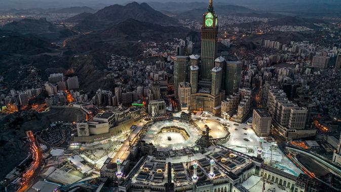 Gambar yang diambil pada 24 Mei 2020 selama jam-jam awal Hari Raya Idul Fitri menunjukkan pandangan udara kota suci Mekkah Arab Saudi dengan Makkah Royal Clock Tower menghadap Masjidil Haram dan Ka'bah.  (Photo by - / AFP)