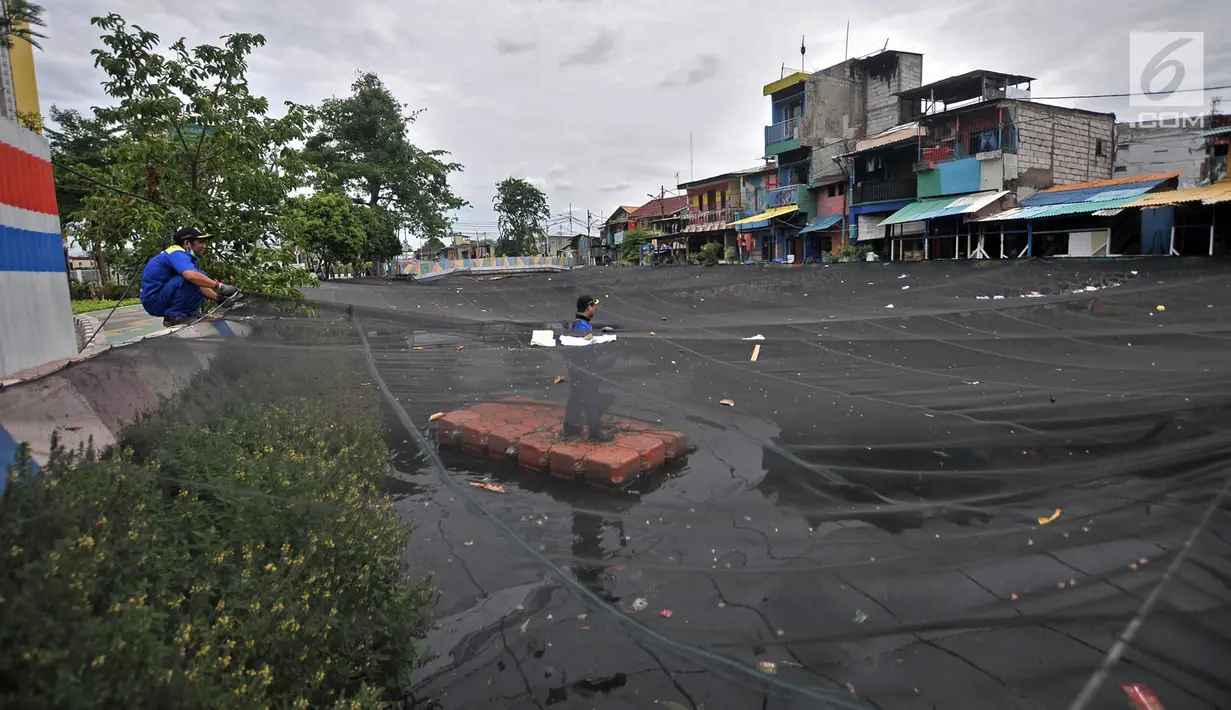 Petugas Dinas Sumber Daya Air Aliran Timur melepas kain waring atau jaring yang menutupi Kali Item di Kemayoran, Jakarta, Rabu (14/11). Pelepasan waring juga untuk mempermudah dalam membersihkan sampah di aliran Kali Item. (Merdeka.com/Iqbal S. Nugroho)