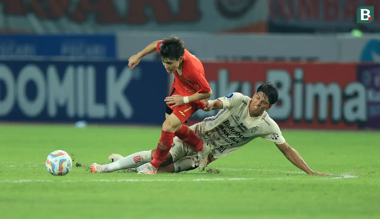<p>Pemain Persija Jakarta, Ryo Matsumura (kiri) terjatuh saat berebut bola dengan pemain Bali United, Elias Dolah pada laga pekan ke-13 BRI Liga 1 2023/2024 di Stadion Patriot Candrabhaga, Bekasi, Minggu (24/9/2023). (Bola.com/M Iqbal Ichsan)</p>