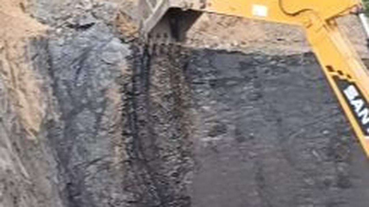 Terlihat di balik tanah cokelat sebuah bukit, terdapat batubara di dalamnya. <br>