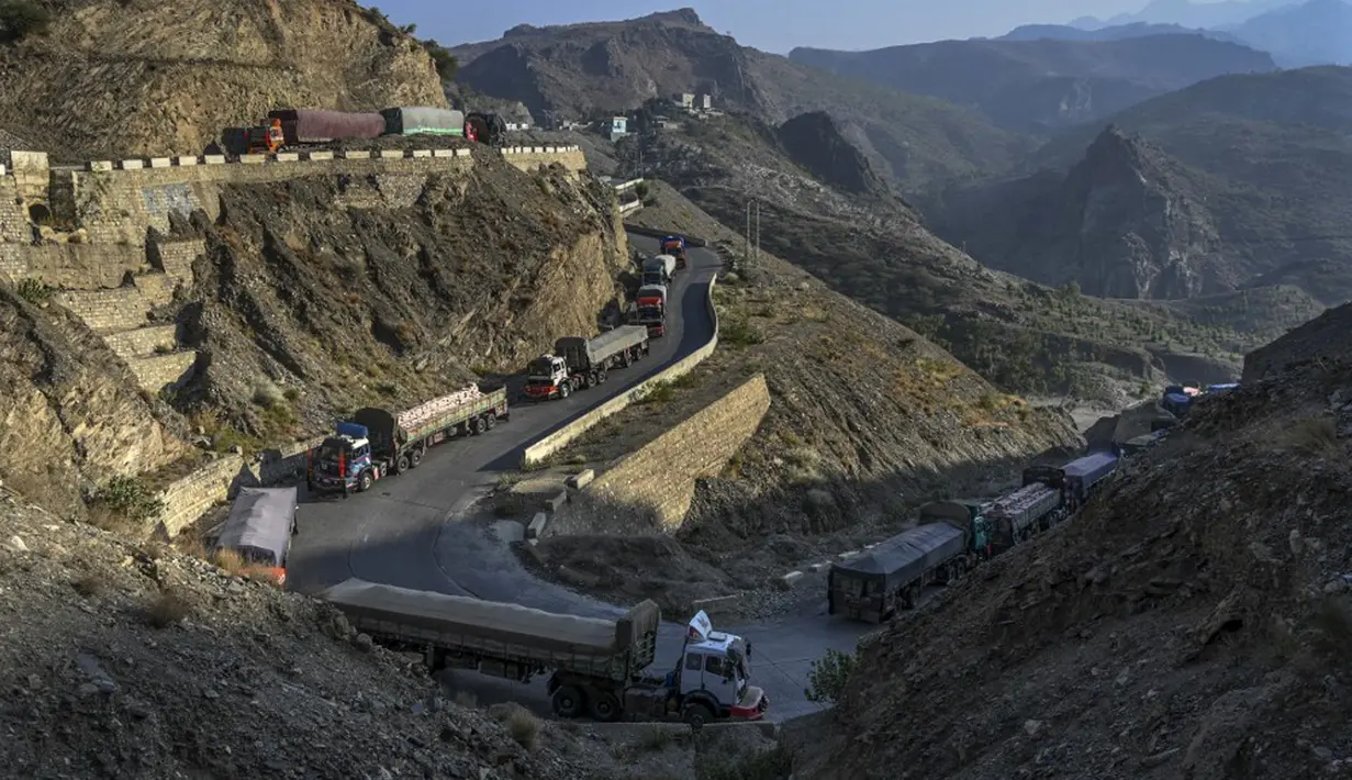 Sejumlah truk diparkir di sepanjang jalan dekat perbatasan Pakistan-Afghanistan di Torkham, Pakistan, Senin (11/9/2023). Perbatasan Torkham ditutup sejak 6 September 2023 menyusul bentrokan antara pasukan perbatasan kedua negara. (Abdul MAJEED/AFP)